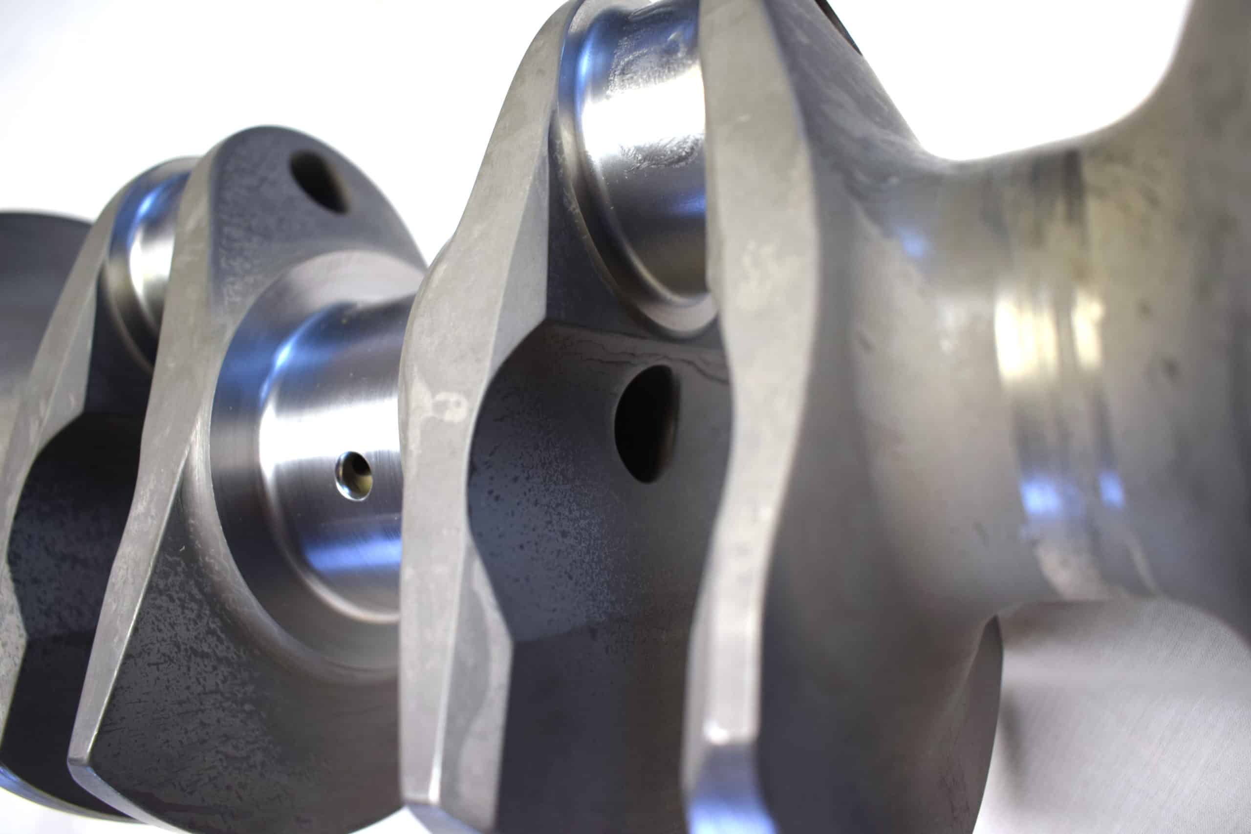 Close-up of Arrow Precision Engineering Billet Steel Crankshaft, Narrow Journal for TR2-4 and Morgan +4, displaying its smooth machined surfaces, rounded counterweights, and detailed precision engineering.