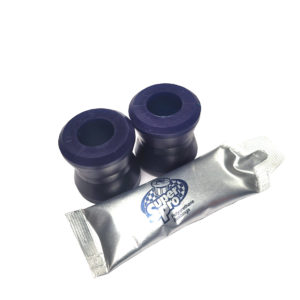 Two dark blue SuperPro Front Lower Damper Bush Sets alongside a silver tube of super lube grease, isolated on a white background.