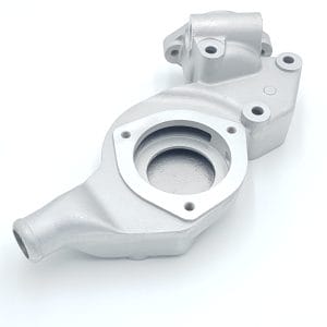 The Racetorations Aluminium Water Pump Housing for Triumph TR5, TR250 & TR6 UPDATED features a silver metallic finish, round opening, mounting holes, and protruding nozzle, shown on a white background.