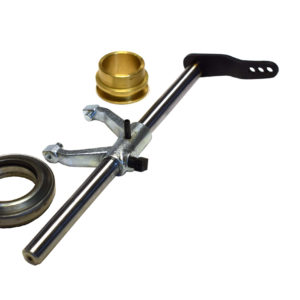 A Racetorations Uprated Gearbox Clutch Release Kit, Mechanical - TR2-6, featuring a clutch hub puller tool with a metal handle and adjustable jaws, accompanied by a small gold-toned component and a circular metallic seal, isolated