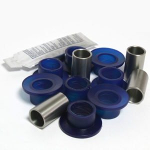 A collection of SuperPro Polyurethane Lower Wishbone Outer Bush Kit - TR4A-6 in various sizes, displayed next to a sealed package on a white background.