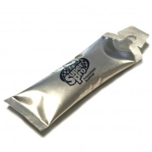 An unopened, silver-colored SuperPro Bush Installation Grease Sachet labeled "Clif Shot Energy Gel, Double Espresso" on a white background, reflecting light.