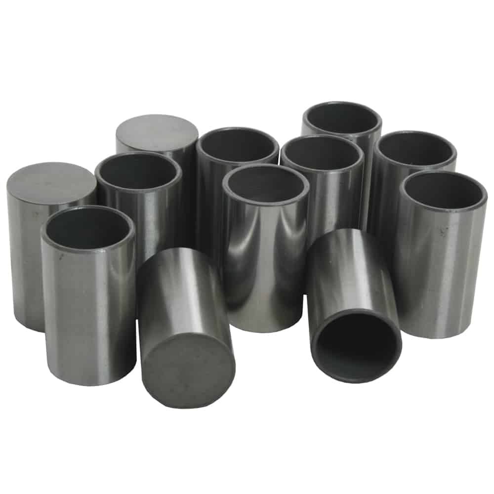 A group of cylindrical steel spacers arranged randomly on a white background. the spacers have a shiny finish and various heights.