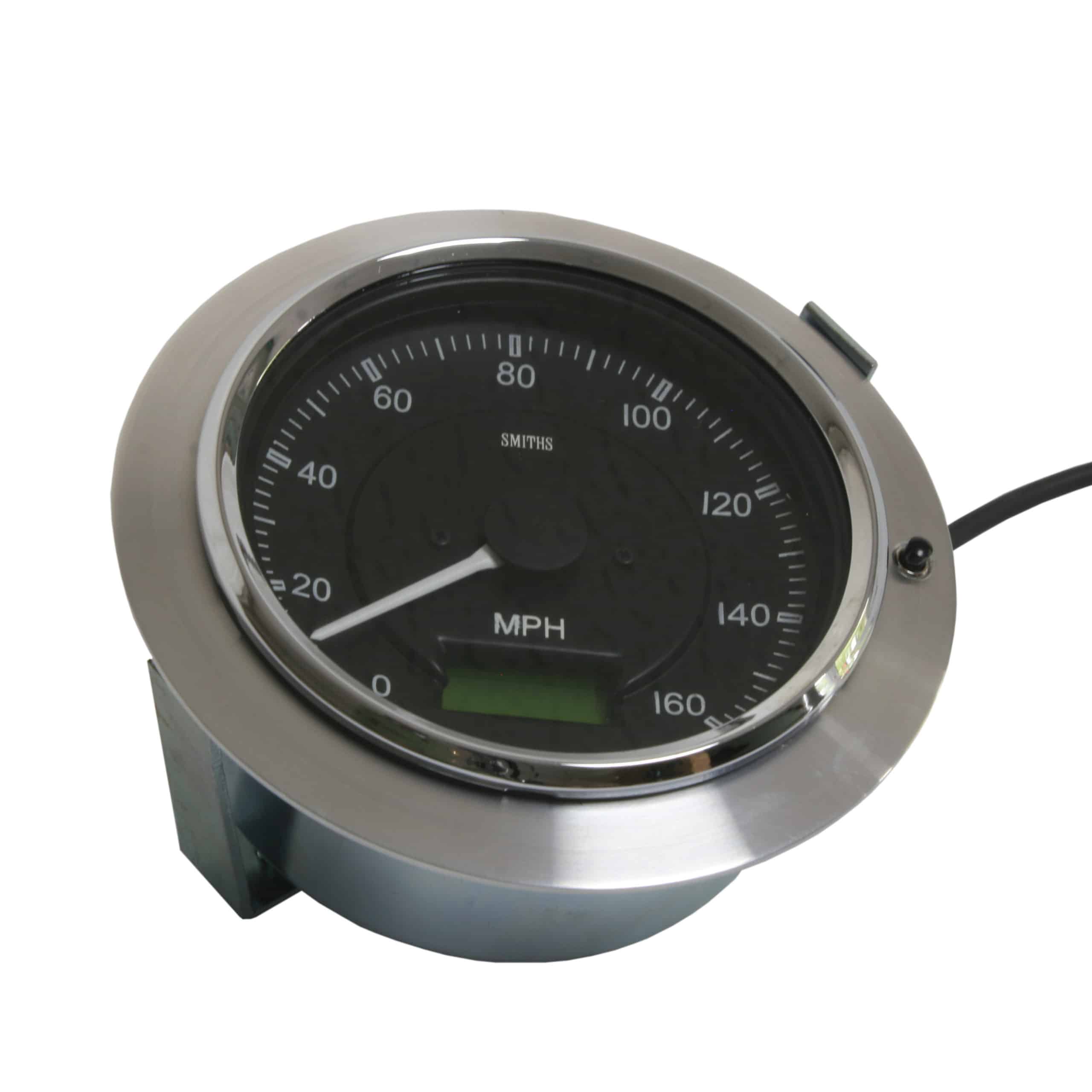 Analog speedometer displaying 0 mph, featuring a metallic finish and a black dial with a Gauge Bezel Adapter, mounted on a metal base. The speedometer has a cable attached and ranges from 0 to 140 mph.