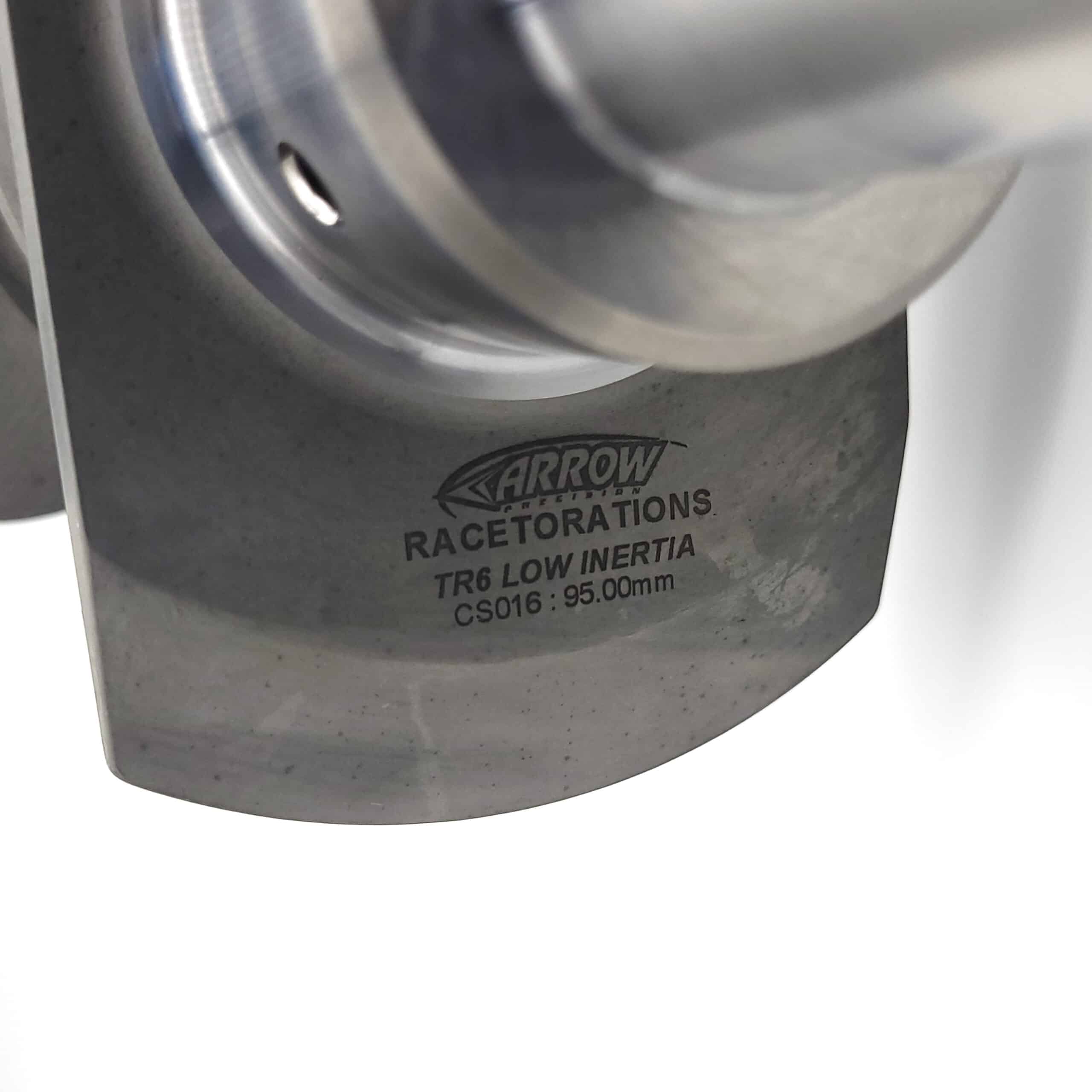 Close-up of an Arrow Precision Engineering Billet Steel Race Crankshaft For TR5-6, engraved with "ARROW RACE TORATIONS TR6 LOW INERTIA CS016: 95.00mm," shown against a white background.