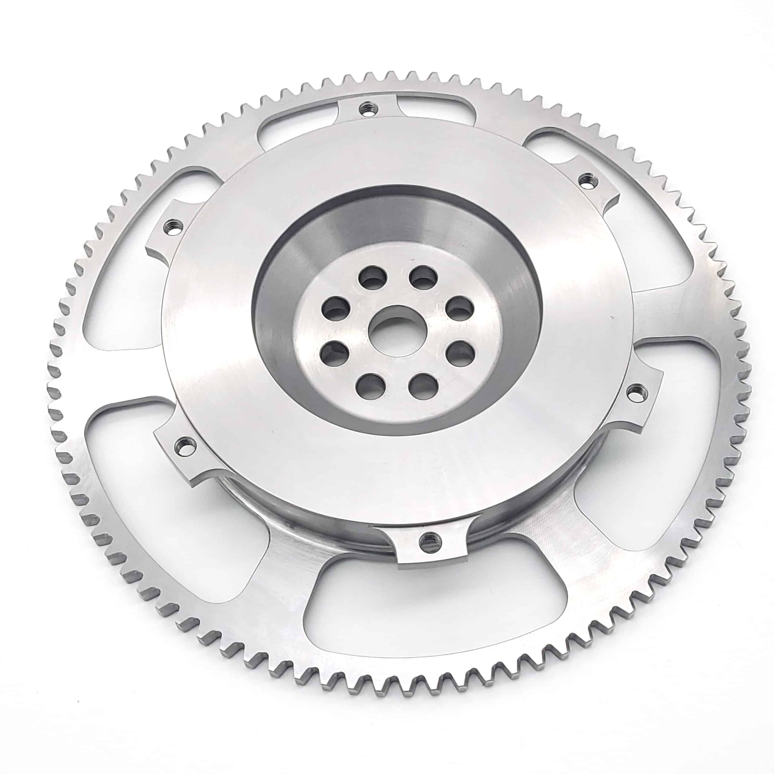 A close-up of the Racetorations Ultralight One-Piece Steel Flywheel with evenly spaced edge teeth and central holes, designed for steel crank, 7ΒΌ" clutch, and suitable for TR2-4A & Morgan +4 models on a white background.