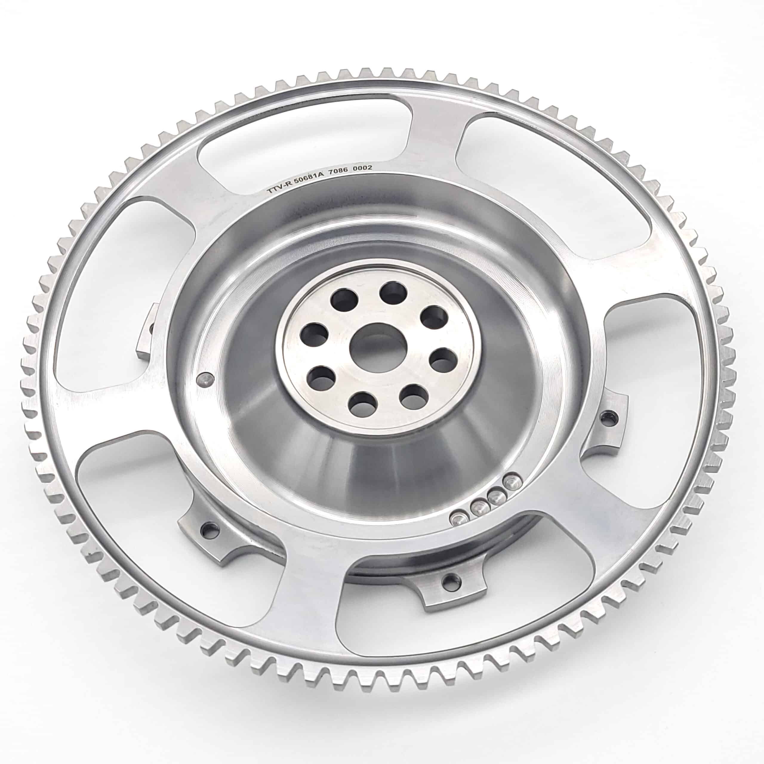 A close-up of the Racetorations Ultralight One-Piece Steel Flywheel for TR2-4A & Morgan +4, featuring a steel crankshaft, multiple centre holes, fine outer teeth, and designed for a 7 1/4" clutch on a white background.