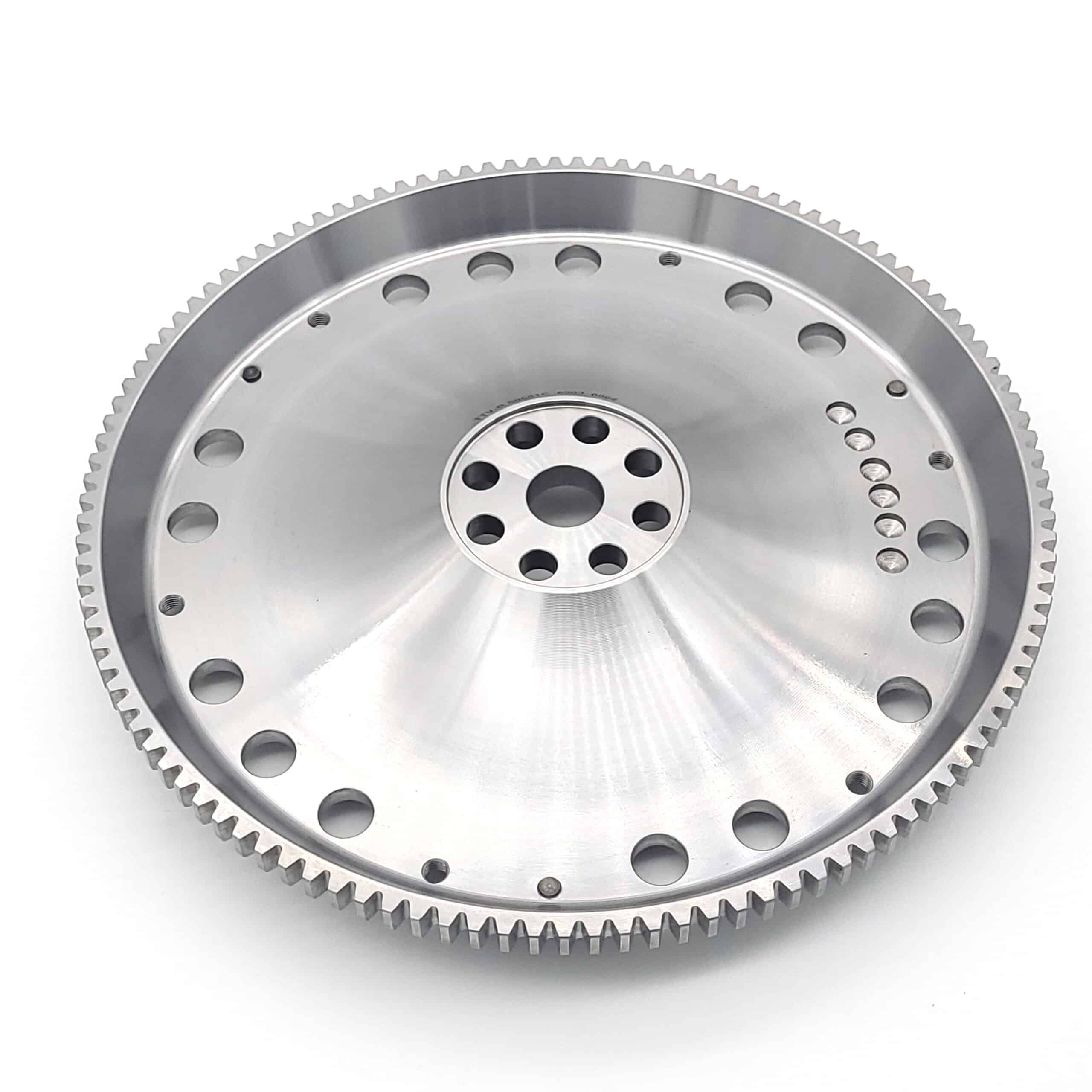 A shiny Racetorations Lightweight One-Piece Steel Flywheel for TR5-6 with an 8 1/2" clutch, featuring a circular shape, multiple centre holes, and fine outer teeth, shown on a plain white background.