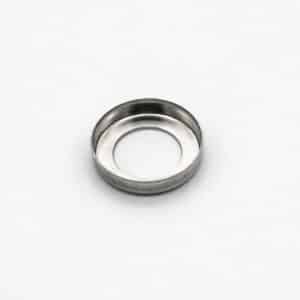 A small, round, metallic ring with a raised outer edge and an open centre, placed on a plain white background.