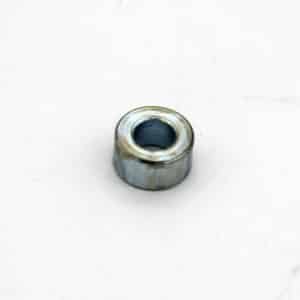 A small, round metallic washer or spacer with a central hole placed on a plain white surface.