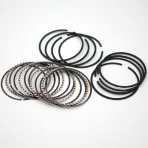 A set of black and metallic engine piston rings arranged in groups on a white background.