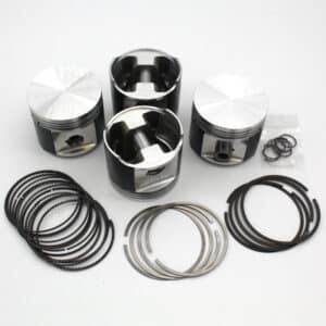 Three engine pistons with shiny tops, surrounded by multiple rings and seals, are arranged on a white background. The pistons are metallic and cylindrical in shape.