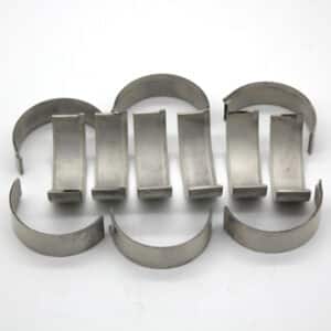 Eight silver-coloured, semi-circular metal bearing shells are arranged in two rows of four on a plain white background.