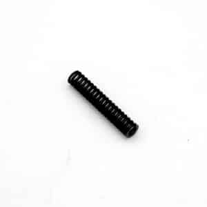 A small black metal coil spring lies diagonally on a plain white background.