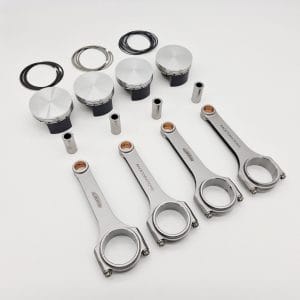 The Racetorations 87mm Slipper Piston & Steel Connecting Rod Set for TR2-4A & Morgan +4 is shown on a white background, featuring four slipper pistons, four steel rods, piston pins, and rings—essential engine components.