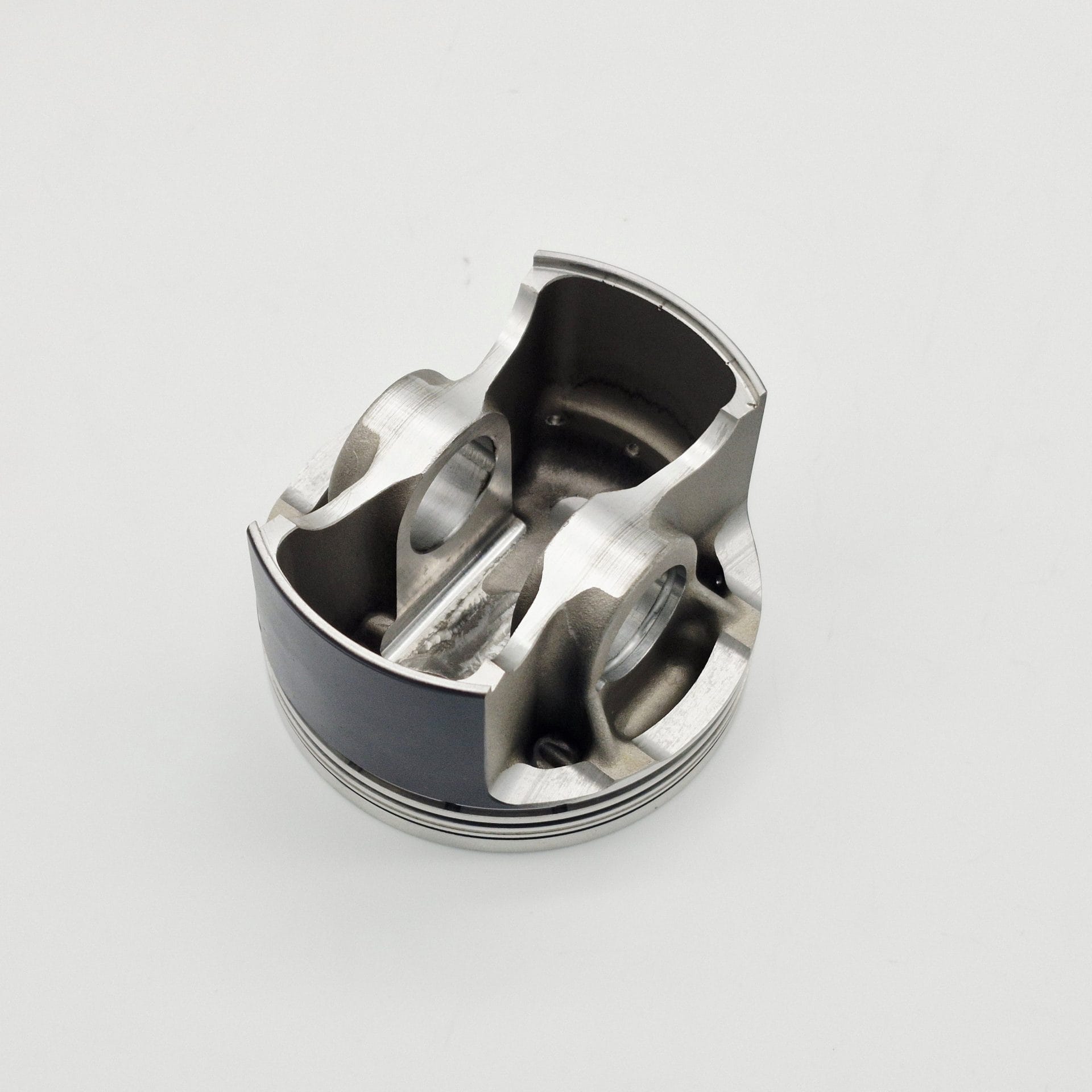 The Racetorations 87mm Slipper Piston & Steel Connecting Rod Set for TR2-4A & Morgan +4 features a smooth, metallic piston with grooves and holes, resting on a plain white surface.