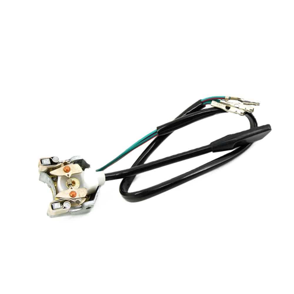 A close-up of the Indicator Switch Triumph TR6 shows an electrical connector with a black cable and three exposed wires—red, green, and black—each ending in metal terminals. The connector features plastic insulation and a metal mounting bracket, as commonly found in this assembly.